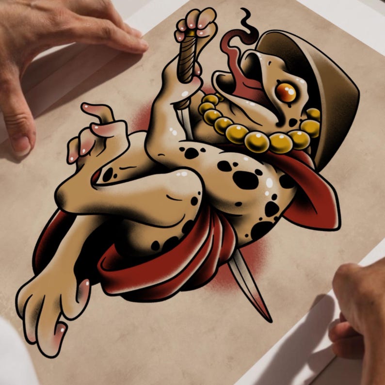 Puede incluir: Ilustraci&oacute;n estilo tatuaje de una criatura parecida a una rana con una daga, que lleva una capa roja y un collar de cuentas doradas. La criatura tiene una capucha marr&oacute;n y est&aacute; sobre un fondo beige. La imagen est&aacute; sujeta por dos manos.