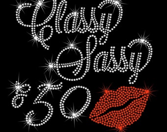 May include: Rhinestone iron-on design featuring the words "Classy & sassy" with the number "50" and a red rhinestone lip. The design measures 9 inches wide by 8.5 inches tall.