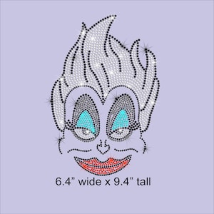 May include: A rhinestone design of a cartoon character's face with light blue eyes and red lips. The design is 6.4" wide and 9.4" tall. The character has white hair and is outlined in black rhinestones. The background is a light purple color.