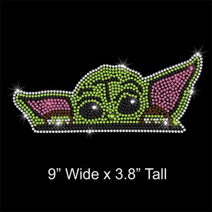 May include: Green, pink, and black rhinestone iron-on design of a popular fictional character. The design measures 9 inches wide by 3.8 inches tall.