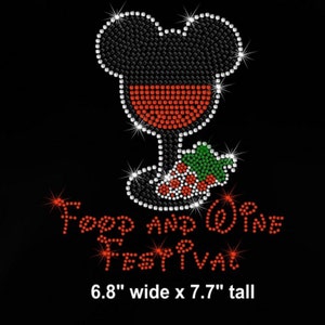 May include: Black graphic design featuring a Mickey Mouse head shape filled with black rhinestones, a wine glass with red rhinestones, and a cluster of green and red rhinestones. The text "Food and Wine Festival" is in red rhinestones. The design is 6.8" wide x 7.7" tall.