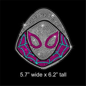 May include: A rhinestone design of a superhero mask, 5.7 inches wide by 6.2 inches tall, on a black background. The mask features white, pink, and teal rhinestones. The text "5.7" wide x 6.2" tall" is at the bottom.