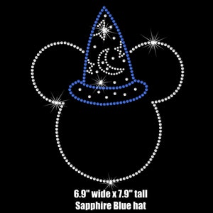 May include: A blue and white rhinestone Mickey Mouse head with a sapphire blue witch hat. The hat is decorated with white rhinestones and a crescent moon. The image text reads "6.9" wide x 7.9" tall Sapphire Blue hat".
