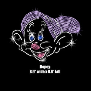 May include: A rhinestone iron-on patch of Dopey from Disney's Snow White. The patch is 8.9 inches wide and 6.6 inches tall. Dopey is wearing a purple hat and has a pink nose and blue eyes.
