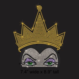 May include: A rhinestone design on a black background. The design features a stylized face with a golden crown, green eyes, and purple eyeshadow. The text at the bottom reads: 7.4" wide x 8.9" tall.