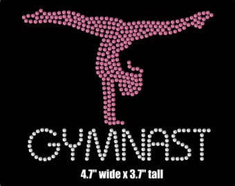 May include: Pink and white rhinestone design of a gymnast doing a handstand. The text "GYMNAST" is below the gymnast. The design is 4.7 inches wide and 3.7 inches tall.