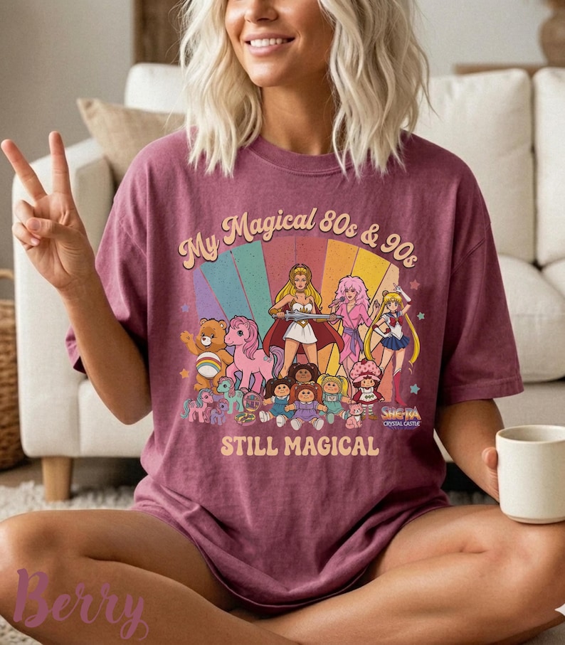May include: A maroon t-shirt with a graphic featuring cartoon characters from the 80s and 90s, including Care Bears, My Little Pony, and Sailor Moon. The text reads "My Magical 80s & 90s STILL MAGICAL".