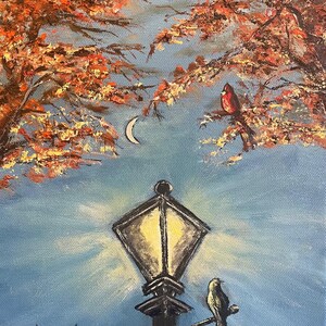 May include: A painting of a street lamp with a bird perched on it. The lamp is lit and there is a crescent moon in the sky. The background is a blue sky with fall leaves in the upper left corner. The artist's signature, "Deb Bailey", is in the lower left corner.