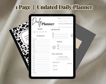 May include: A black and white daily planner with sections for mood, gratitude, schedule, goals, and meal tracking. The planner is undated and has a simple design.