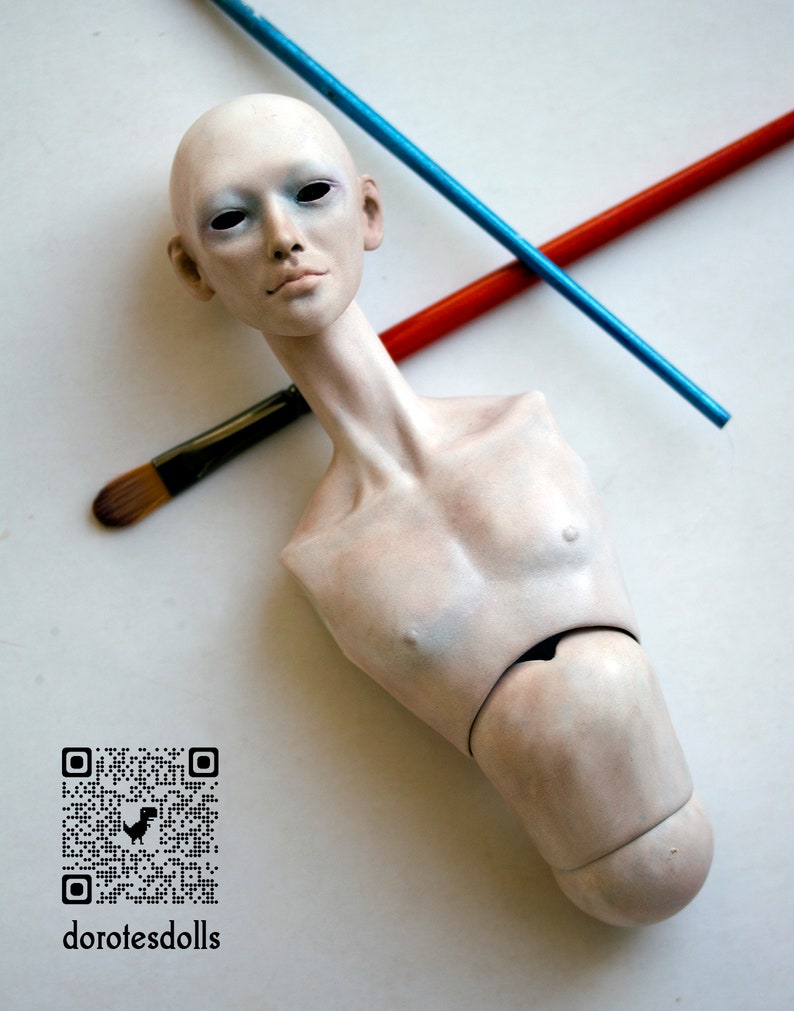K&ouml;nnte beinhalten: Ein wei&szlig;er Porzellan-Puppenkopf und -Torso mit bemaltem Gesicht und einem QR-Code mit dem Text "dorotesdolls".