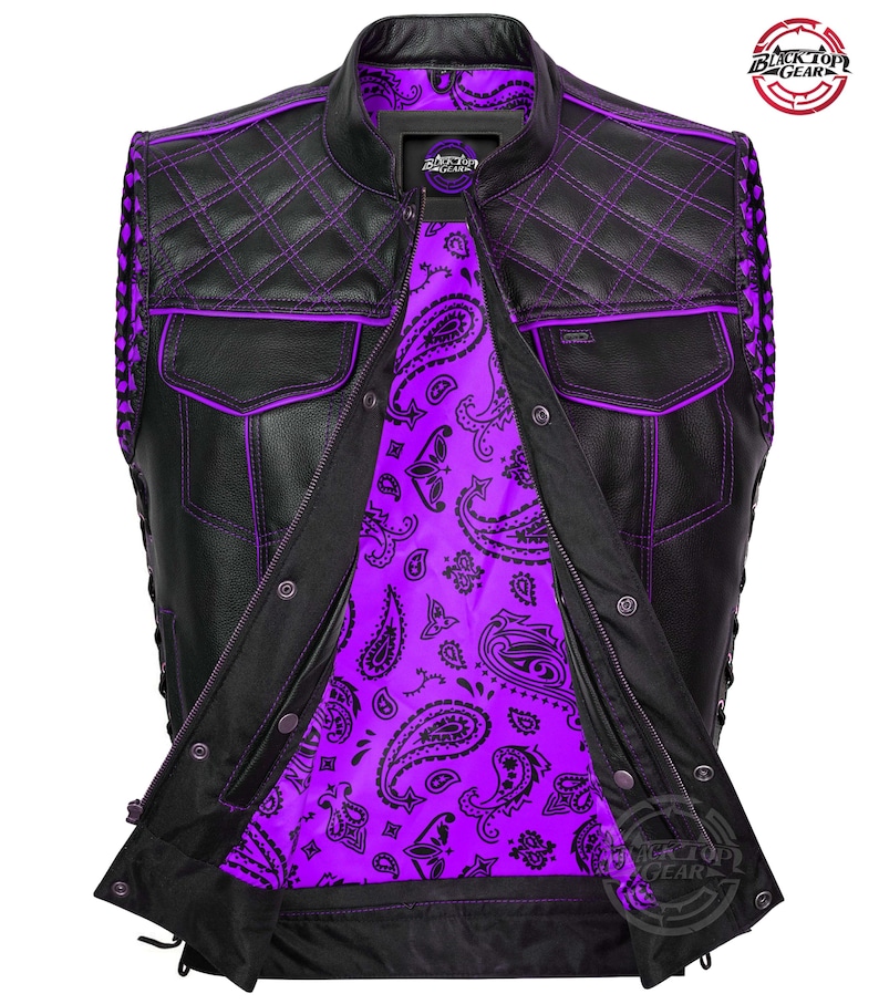 May include: Black leather vest with purple stitching and a paisley purple lining. The vest features a quilted pattern on the shoulders and upper back, two front pockets, and a zipper closure. The vest has a round collar and a Black Top Gear logo.