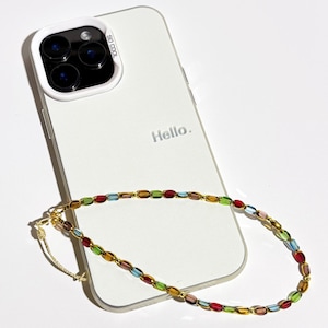 May include: A white smartphone with a protective case and the text "Hello." is shown. A colorful beaded phone strap with red, green, blue, and yellow beads is draped across the phone. The case has the text "SO COOL."