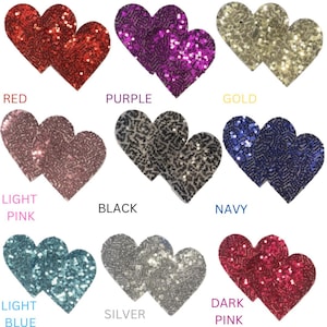 May include: Ten pairs of heart-shaped, double-layered, sparkly, adhesive pasties in various colors: red, purple, gold, light pink, black, navy, light blue, silver, and dark pink.