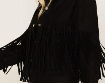 May include: Black suede jacket with fringe detailing. The jacket features a button-down front, a classic collar, and long sleeves. The fringe is along the chest and sleeves, adding a Western-inspired flair to the garment.