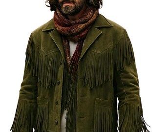 May include: Olive green suede jacket with fringe detailing, paired with a brown hat and a patterned scarf. The jacket features a button-up front and pockets. The outfit is completed with blue jeans.