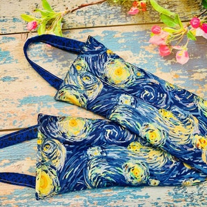 May include: Two blue and yellow fabric bags with a starry night print. The bags have handles and are made of a soft, textured fabric.