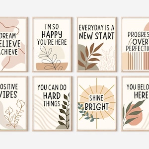 May include: A set of eight rectangular wall art prints featuring cream backgrounds with earthy-toned abstract shapes, botanical line drawings, and black text including phrases like Dream Believe Achieve, Everyday Is A New Start, and Shine Bright.