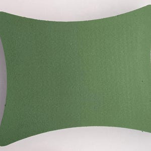 May include: A green foam block with a curved shape, ideal for floral arrangements.