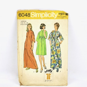 May include: Simplicity sewing pattern number 6048 for a long dress. The pattern is for sizes 12-14 for misses and women. The pattern shows three different styles of the dress, one in orange with white polka dots, one in green, and one in blue with yellow flowers. The pattern is labeled "Jiffy" and has a price of $1.00.