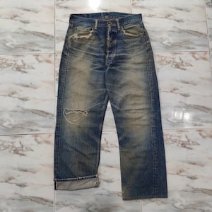 May include: A pair of blue denim jeans with faded and distressed details. The jeans have a straight leg fit and are cuffed at the bottom.