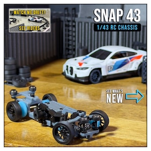 May include: Image of a grey and black 1/43 RC chassis with black wheels and blue detailing. A white and blue race car is in the background. The text "SNAP 43 1/43 RC CHASSIS" is displayed. The image also includes the text "SEE WHAT'S NEW".