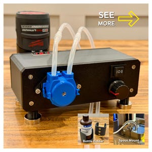 Könnte beinhalten: Ein schwarzes und blaues Pumpensystem mit transparenten Schläuchen, einem schwarzen Steuerkasten und einer rot-schwarzen Batterie. Das Bild enthält einen Flaschenhalter und eine Ausgussbefestigung. Der Text "SEE MORE" ist sichtbar.