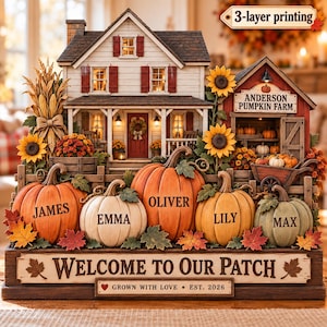 Może przedstawiać: Dekoracyjna ozdoba stołowa przedstawiająca dom i stodołę z napisem Anderson Pumpkin Farm. Pięć dyń na pierwszym planie jest spersonalizowanych imionami James, Emma, Oliver, Lily i Max. Tabliczka głosi Welcome to Our Patch, Grown with Love, Est. 2026.