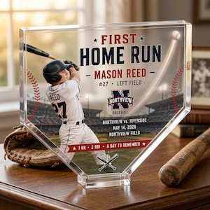 Könnte beinhalten: Eine klare Acryl-Auszeichnung in Form einer Home Plate mit einem Baseballspieler in weißer Uniform und dem Text FIRST HOME RUN, MASON REED, #27, LEFT FIELD, NORTHVIEW BASEBALL, NORTHVIEW VS. RIVERSIDE, 14. MAI 2026, 1 HR 2 RBI A DAY TO REMEMBER.