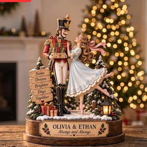 May include: A decorative figurine featuring a nutcracker in a red uniform holding gifts and a dancer in a light blue dress. A wooden sign reads Same Dream Brighter Days Together. The base is inscribed with OLIVIA & ETHAN Always and Always.