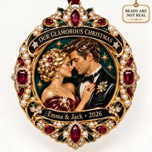 Puede incluir: Un adorno navideño ovalado en tono dorado con una pareja en traje de gala. El marco está decorado con gemas rojas, perlas blancas y cristales transparentes. Texto: OUR GLAMOROUS CHRISTMAS, Emma & Jack, 2026. BEADS ARE NOT REAL.