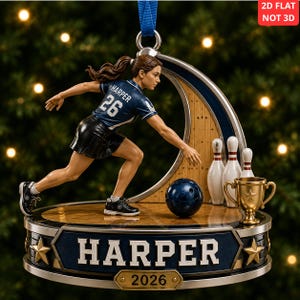 May include: A 2D flat bowling-themed Christmas ornament featuring a figure in a navy blue jersey with the name HARPER and number 26, a bowling ball, pins, and a gold trophy. The base displays the name HARPER and the year 2026 with gold stars.