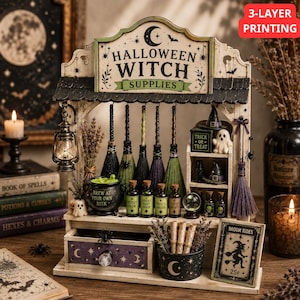 Peut inclure: Un présentoir en bois pour fournitures de sorcière d'Halloween avec une enseigne au croissant de lune, cinq balais miniatures, un chaudron marqué 'Brew at Your Own Risk', des fioles, un fantôme, une boule de cristal et un tiroir étoilé.