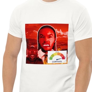 May include: White t-shirt featuring a graphic design with a red background and a face with an angry expression. A gauge labeled "CORTISOL" indicates a high level. The design includes two faces.