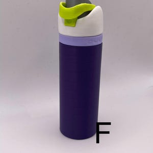 Peut inclure: Une bouteille d'eau violette avec un couvercle blanc et une boucle de transport verte. La bouteille a une bande violette clair autour du milieu.