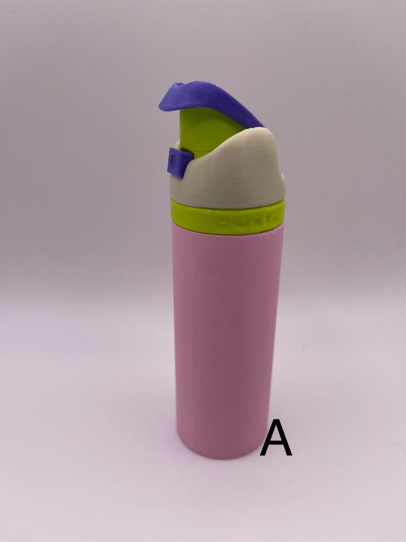 Peut inclure: Une bouteille d'eau rose avec un couvercle blanc et vert et un bouchon rabattable violet. La bouteille est &eacute;tiquet&eacute;e avec la lettre "A".