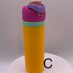 Peut inclure: Une bouteille d'eau r&eacute;utilisable jaune avec un couvercle rose, vert et violet. Le couvercle a un bouchon rabattable.