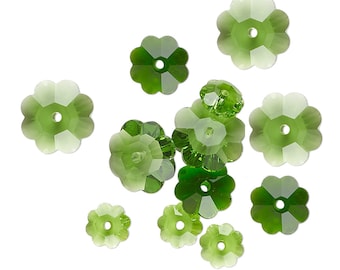 May include: A scattering of green glass flower-shaped beads with a hole in the center of each bead.