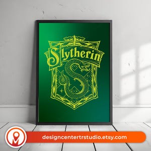 May include: A framed print featuring the Slytherin crest from the Harry Potter series. The crest is a detailed design in yellow, set against a gradient green background. The frame is black, and the print is displayed against a white wall.