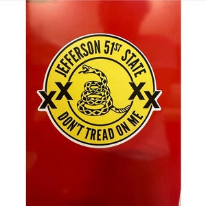 May include: A yellow and black circular sticker with the text "Jefferson 51st State Don't Tread On Me" and a coiled snake with an 'X' on each side.