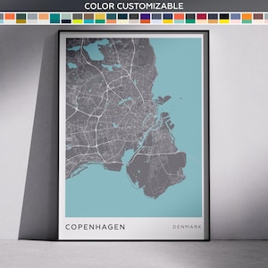 May include: A framed map of Copenhagen, Denmark, in grey and teal. The city's layout is detailed, with roads and buildings visible. The text "COLOR CUSTOMIZABLE" is at the top. The city name and country are at the bottom.