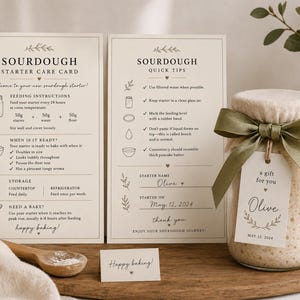 Peut inclure: Deux cartes rectangulaires intitulées Sourdough Starter Care Card et Sourdough Quick Tips avec instructions et icônes, à côté d'un bocal en verre rempli de levain, recouvert d'un tissu, d'un ruban vert olive et d'une étiquette cadeau nommée Olive.