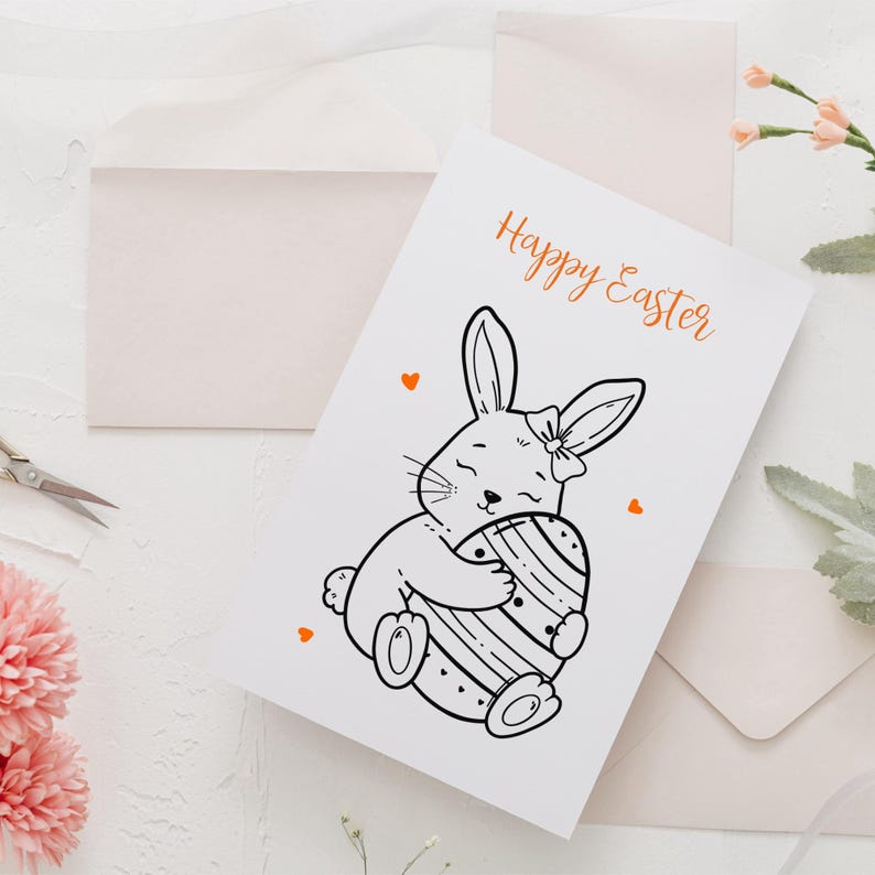 May include: White greeting card with the text "Happy Easter" in orange script. The card features a black and white illustration of a bunny hugging a decorated Easter egg. Small orange hearts are scattered around the card.