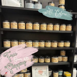 K&ouml;nnte beinhalten: Ein Regal mit Dixie Belle Chalk Mineral Paint in verschiedenen Farben. Das Schild &uuml;ber dem Regal lautet "Alle Farben". Ein rosa Schild unter dem Regal lautet "Kostenloser Versand ab 35 &euro;".