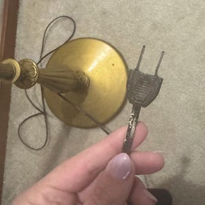 May include: A gold floor lamp with a round base and a black cord with a vintage two-prong plug.