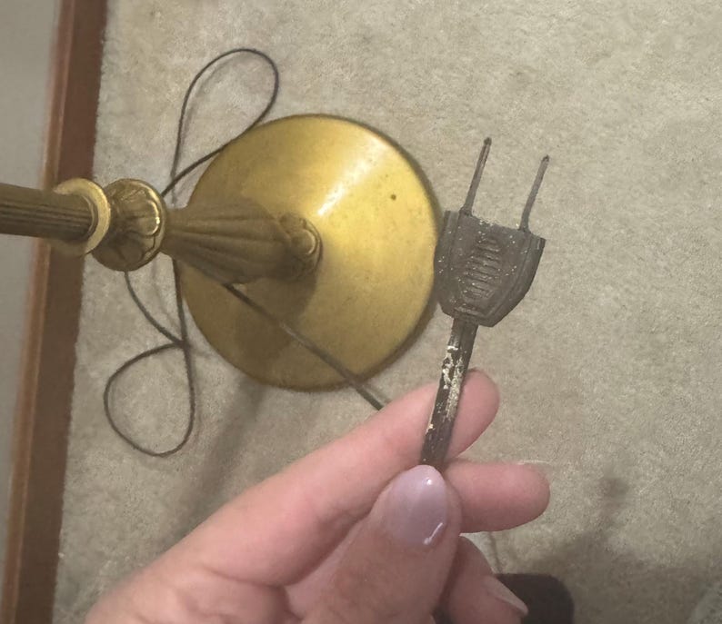 May include: A gold floor lamp with a round base and a black cord with a vintage two-prong plug.