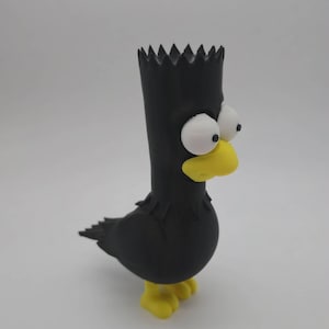 May include: A black figurine resembling Bart Simpson as a bird. The figure has a black body, head, and hair, with white eyes and a yellow beak and feet. The figurine is standing on a white surface.