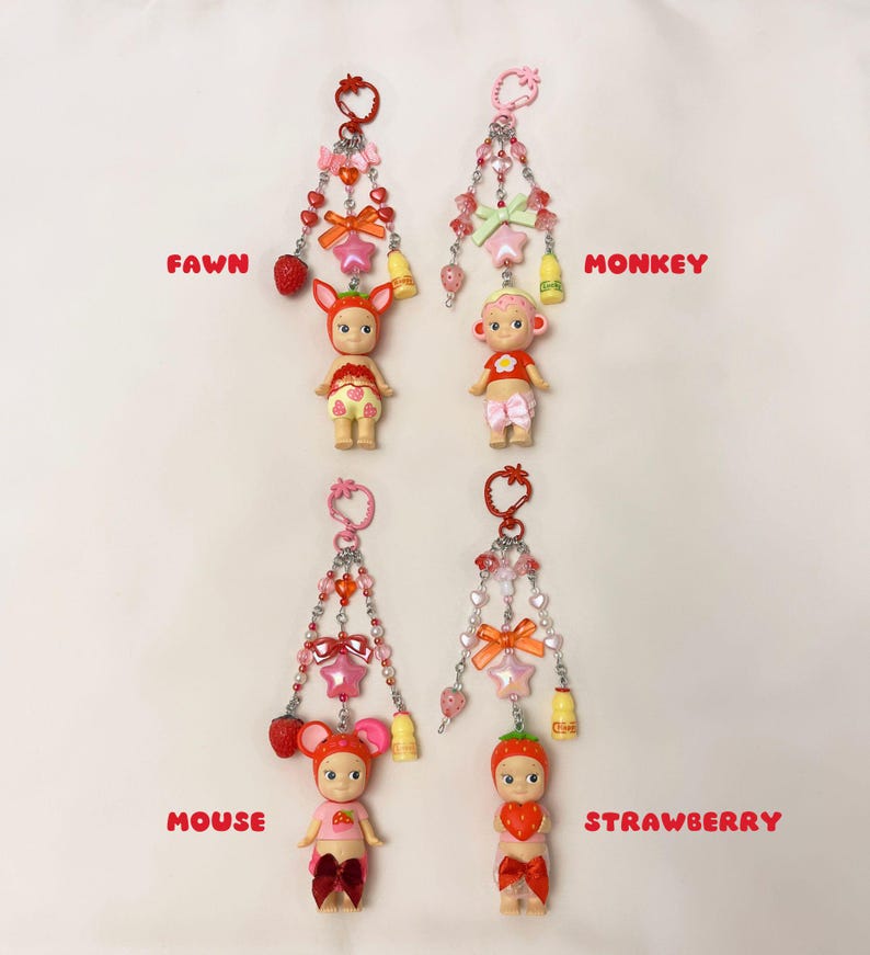 Puede incluir: Cuatro llaveros con peque&ntilde;as figuras, cada uno con un tema diferente de animal o fruta. Las figuras est&aacute;n unidas a cadenas decorativas con cuentas, lazos y abalorios. Las etiquetas de texto dicen "FAWN", "MONKEY", "MOUSE" y "STRAWBERRY".