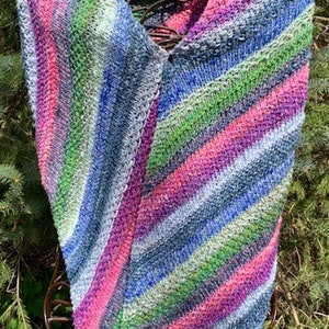 May include: A triangular knitted shawl with a diagonal striped pattern in shades of pink, blue, green, and grey.