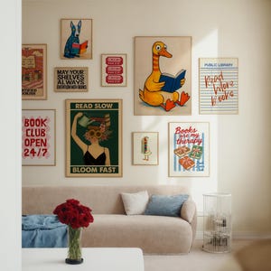 May include: A collection of framed art prints with a literary theme. The prints feature illustrations of a dog reading, a duck reading, and various book-related quotes such as "Read More Books" and "Books are my therapy."