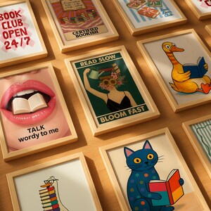 May include: A collection of framed art prints with a book-themed aesthetic. The prints feature various illustrations and text, including a duck reading a book, a cat reading, and the phrases "Book Club Open 24/7" and "Talk wordy to me."